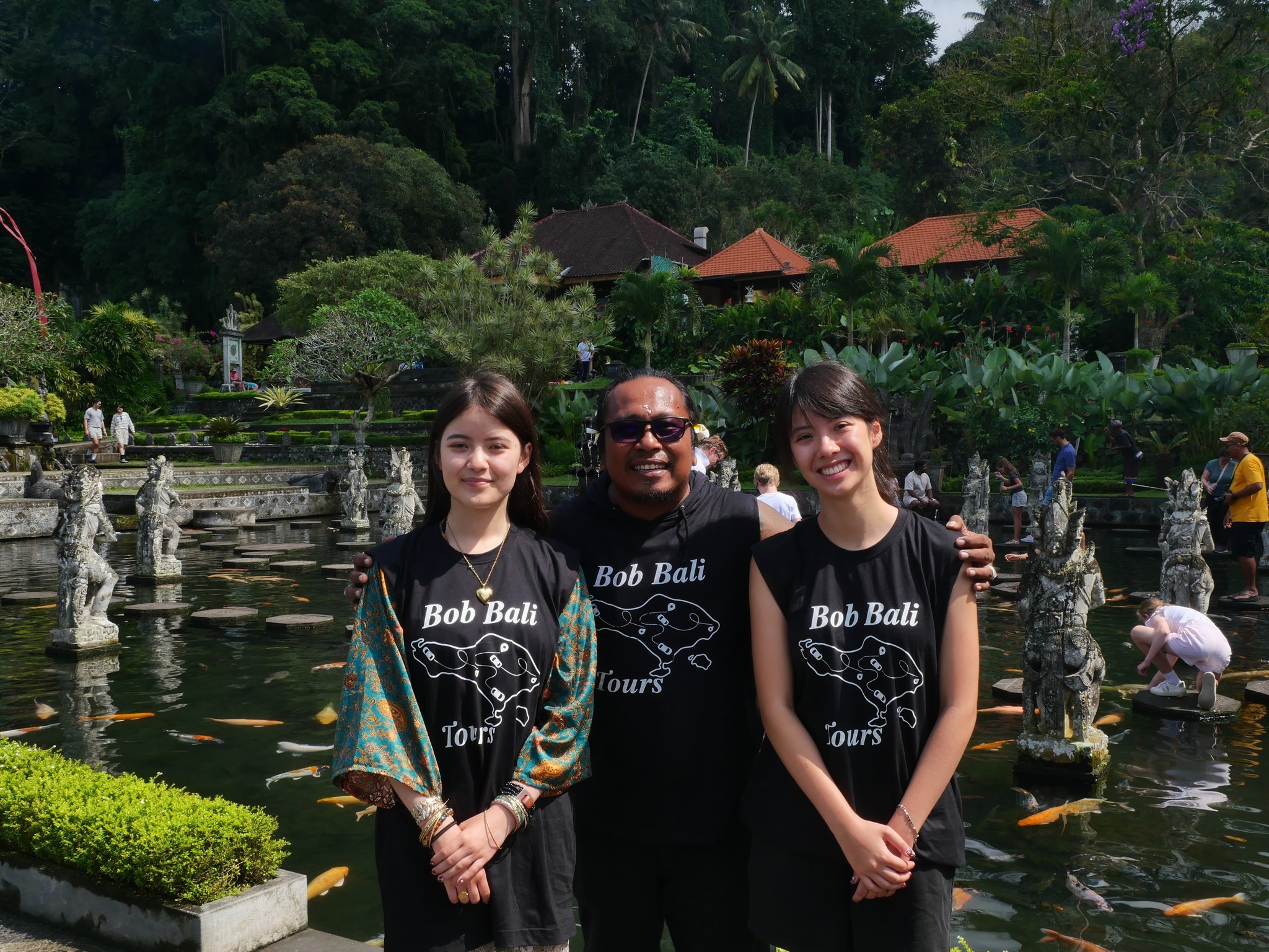 Visitors capturing moments at Tirta Gangga Water Palace fountain background East Bali